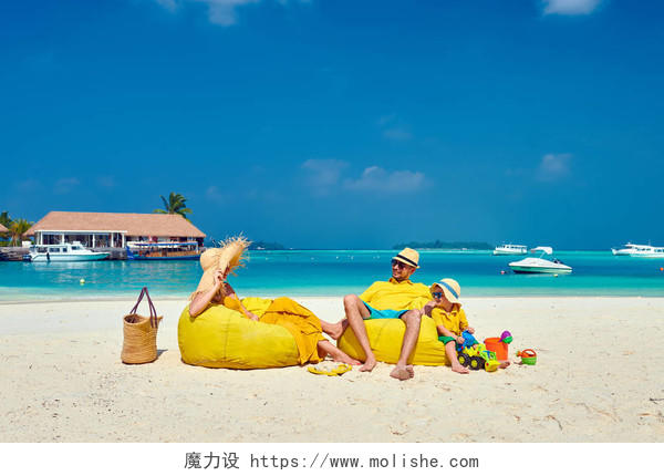 马尔代夫的暑假年轻夫妇与3岁的男孩在海滩上